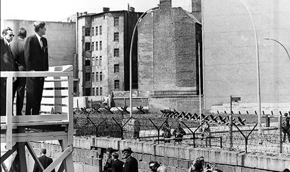 President Kennedy stands on an observation platform to look over the Berlin Wall towards East Berlin. (AP Photo)